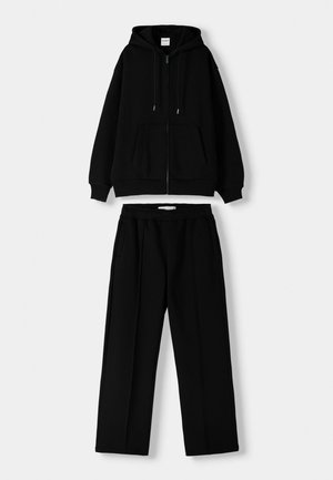 Black zip-up hoodie with drawstrings and front pockets, paired with matching black pants featuring an elastic waistband and side pockets.