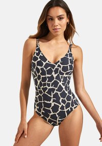 Maillot de bain une pièce de couleur marine avec un motif de girafe blanc, doté de bretelles réglables et d'un décolleté en V. Texture lisse et coupe ajustée.