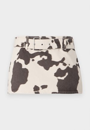 Cow-print denim mini skirt with a belted waist. Features contrasting dark brown shapes on a light background. Textured fabric with sturdy stitching.
