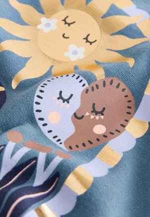 Tekstil med en lysblå baggrund og farverige illustrationer af en sol, to hjerter og stiliserede planter med gyldne accenter.