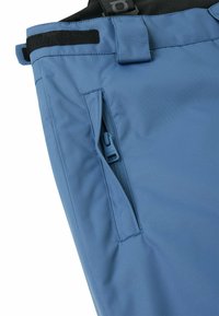 Blaue wasserdichte Hose mit einer seitlichen Reißverschlusstasche, einem verstellbaren Bund mit Klettverschluss und einem glatten, strapazierfähigen Stoff. 