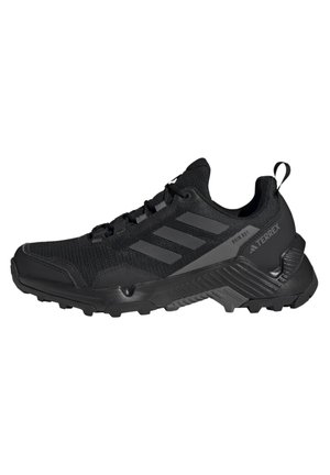 Czarny but do biegania trailowego Adidas Terrex z teksturowaną podeszwą, trzema paskami po bokach oraz napisami „Rain RDY” i „Terrex” po boku.
