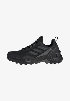Chaussure de trail Adidas Terrex noire avec semelle texturée, trois bandes latérales, et inscriptions « Rain RDY » et « Terrex » sur le côté.
