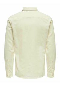 Lange mouwen shirt van zacht, off-wit stof. Heeft een klassieke kraag, knoopmanchetten en een gebogen zoom met een schone, naadloze achterkant.