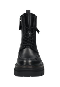 Zwarte leren veterschoenen tot de enkel met een dikke zool en een zijrits, van voren bekeken op een witte achtergrond.