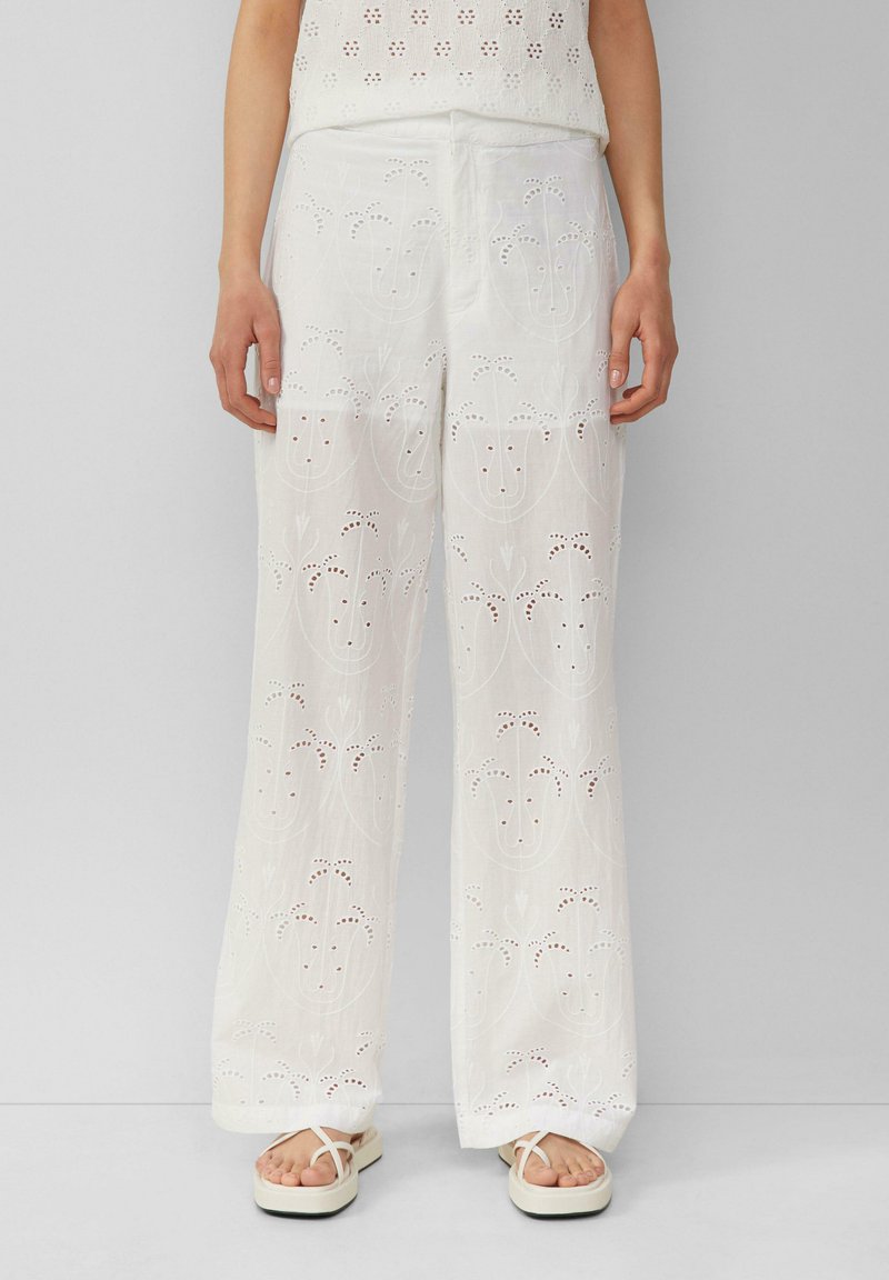 Weiße, leichte bestickte Hosen mit floralen Cut-Out-Mustern und dekorativer Naht, die einen weiten Beinanschnitt und frontale Taschen aufweisen.