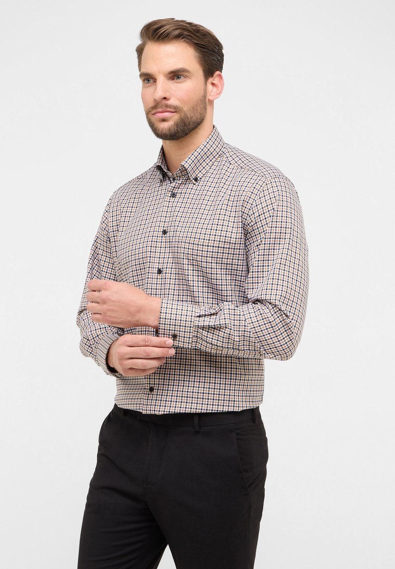 Camicetta con pattern a quadri in beige e blu navy, maniche lunghe e colletto all'italiana. Presenta bottoni neri e una vestibilità su misura.