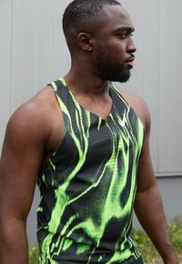 Canottiera da uomo sportiva con base nera e vivaci motivi verdi ondulati, realizzata in tessuto leggero e traspirante, con design a scollatura a V.