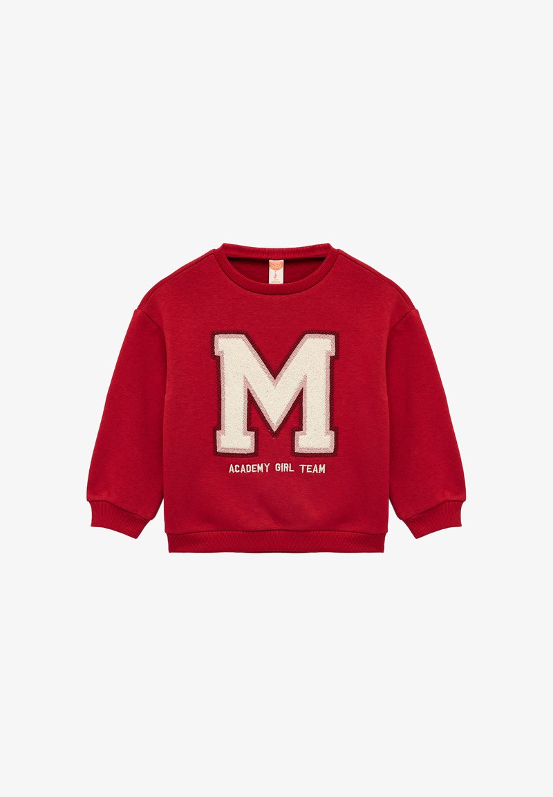 Czerwona bluza z miękkiego materiału, ozdobiona dużą, haftowaną białą literą "M" oraz napisem "ACADEMY GIRL TEAM" poniżej. Prążkowane mankiety i dół.
