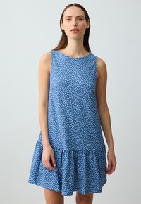 Abito senza maniche blu con pois bianchi, caratterizzato da un orlo svasato e tessuto testurizzato. Scollo liscio e vestibilità comoda progettata per il massimo comfort.
