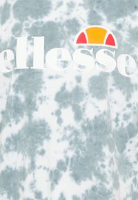 T-shirt gris tie-dye avec un grand logo blanc "ellesse" et un emblème de soleil coloré avec des accents rouges et oranges. Texture de tissu douce.