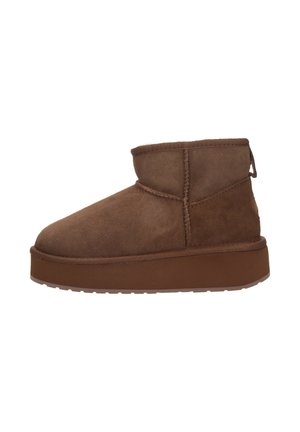 Stivaletto in suede marrone con punta arrotondata, dettagli cuciti e suola piatta in gomma. Collo corto con una linguetta sul retro.