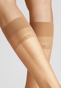 Beige Oberschenkelstrümpfe mit glatter Textur, ausgestattet mit einem breiten, elastischen Bündchen und dezentem Branding nahe der Spitze.