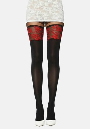 Zwarte dijhoge kousen met rode bloemenkant bovenranden, gedragen met een witte kanten rok en witte hoge hakken, tegen een effen achtergrond.