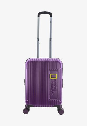 Purple hard-shell suitcase with vertical ribbed texture, retractable silver handle, and four rotating wheels. Features a yellow accent and logo.