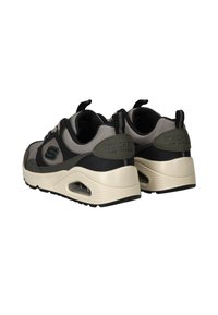 Schwarze und graue Sportsneaker mit Obermaterial aus Mesh, gepolstertem Kragen und beigem Zwischensohlenelement mit Luftpolsterung. "SKECHERS"-Logo an der Ferse.