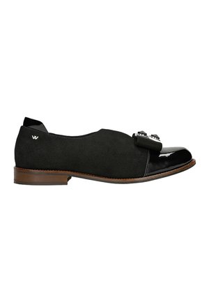 Mocassini in suede nera con punta in vernice nera lucida, caratterizzati da un fiocco decorativo e dettagli metallici. Tacco in legno marrone.