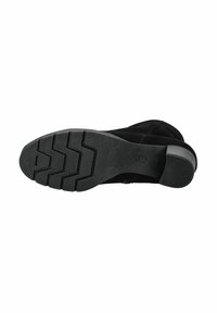Zwarte suède enkellaars met een rubberen zool, voorzien van een zigzagprofiel voor grip en een ronde hak voor stabiliteit.