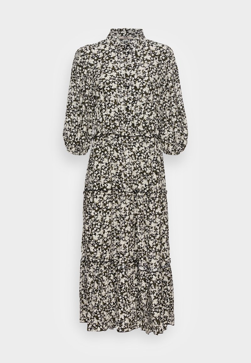 Robe midi fleurie noir et blanc avec manches bouffantes, col montant, boutonnage devant et jupe à volants sur un fond uni clair.