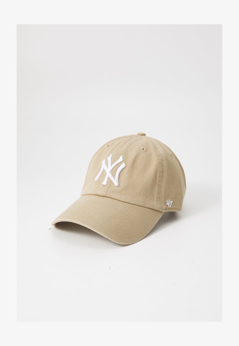 Khaki baseball cap, bomuldsstof, krummet skygge, med hvidt broderet New York Yankees-logo på fronten samt lille logo på siden.