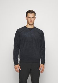 Mustat fleece-huppari, jossa on pyöreä pääntie, pitkät hihat ja hillitty Columbia-logo painettuna eteen. Silkkinen, teksturoitu kangas.