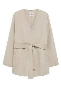 Beige wikkeljas gemaakt van zachte stof. Heeft een V-hals, lange mouwen, ceintuur in de taille en voorzakken. Soepele textuur met minimale details.