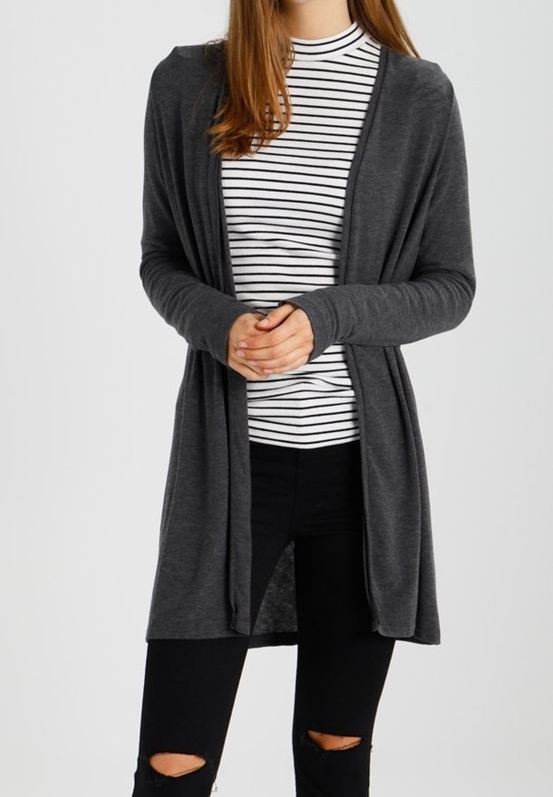 Cárdigan largo gris hecho de tela suave, diseño de frente abierto, usado sobre una camiseta a rayas blancas y negras, combinado con jeans negros rasgados.