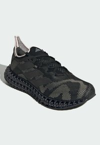 Zapatilla de running negra con parte superior de tejido de punto, tres franjas laterales, suela intrincada impresa en 3D y una lengüeta en el talón, mostrada en un ángulo ligeramente elevado sobre un fondo claro.