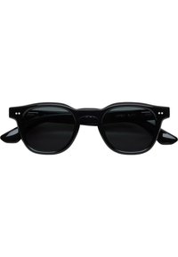 Ochelari de soare negri cu lentile rotunde, cadrul gros din plastic, accente distinctive pe brate si o usor conturare pe linia sprancenei.