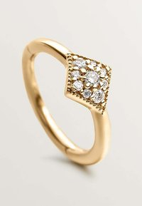 Anillo de oro con una parte superior en forma de diamante con múltiples piedras transparentes engastadas en una base de oro texturizada. Banda lisa con un acabado pulido.