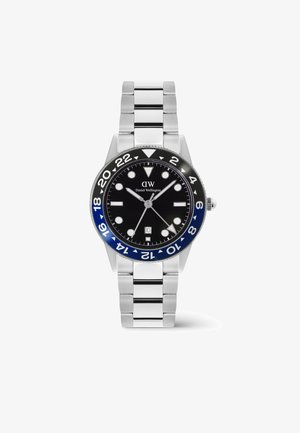 Edelstahluhr von Daniel Wellington mit schwarzem und blauem 24-Stunden-Lünette, schwarzem Zifferblatt, silbernen Zeigern, runden Markierungen und Datumsanzeige bei 6 Uhr.