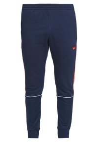 Námořnickým sportovním teplákům z měkké tkaniny dominují boční pruhy v oranžové barvě, bílé žebrované manžety a vyšitá logo na stehně.