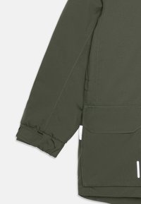 Giacca verde oliva con tasca con zip, polsini elasticizzati, taglio dritto e dettagli riflettenti per la visibilità. Tessuto liscio e resistente all'acqua.