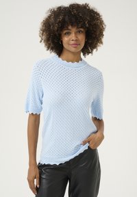 Šviesiai mėlynas megztukas su trumpomis rankovėmis, su banginiu apykakle ir apatine dalimi, turintis tekstūruotą atvirą raštą. Derinamas su juodais odiniais kelnėmis.