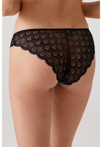 Zwarte kant onderbroek met een golvende rand, bloemenpatroon en een contrasterende tailleband. Zachte textuur met ingewikkelde details.