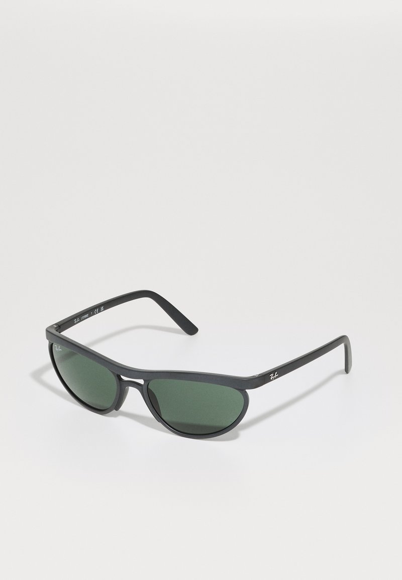 Óculos de sol com uma armação de plástico preto, lentes verdes e um design envolvente e elegante. Apresenta uma marcação subtil nas hastes.