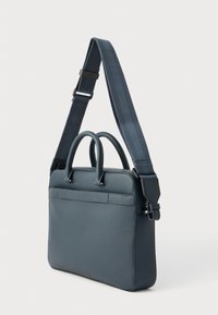 Blå lædermappe med to håndtag øverst, justerbar skulderrem og lynlås til lukning. Glat tekstur, minimalistisk design.