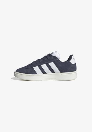 Las zapatillas de ante azul marino presentan tres rayas blancas a un lado, un cuello acolchado blanco y una suela de goma texturizada para mayor tracción.
