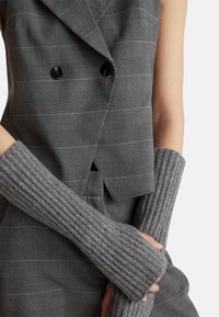 Szare, dziane ocieplacze na ręce o żeberkowanej strukturze, zestawione z szarym, wzorzystym, dwurzędowym żakietem z czarnymi guzikami.