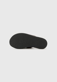 Black shoe sole with textured rubber material, rounded shape, and a slightly raised arch. Flat design with no visible hardware or accents.