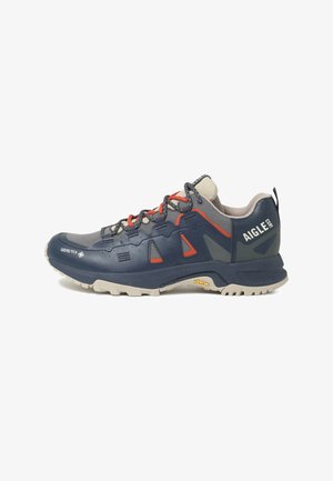 Navy and gray hiking shoe with orange laces, Gore-Tex technology, Vibram sole, and Aigle 1853 branding on the heel.