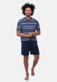 Raitapaita lyhythihaisena, sinisen, punaisen ja vaaleansinisen sävyissä, yhdistettynä sinisiin shortseihin. Pehmeä, hengittävä kangas; rento istuvuus.