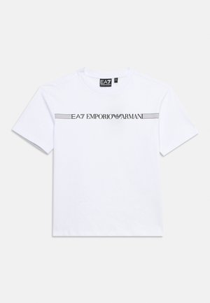 Bijela majica kratkih rukava s okruglim izrezom i crnim logotipom "EA7 Emporio Armani" te vodoravnim linijama preko prsa.