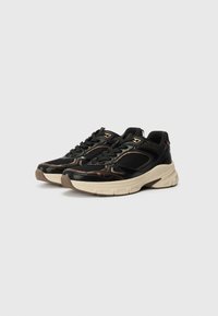 Sneaker nere con un mix di materiali in rete e testurizzati, suola beige spessa e accenti in rame lungo i lati.