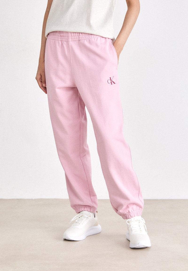 Roze joggingbroek met een elastische tailleband, manchetten bij de enkels en een klein geborduurd logo. Gemaakt van zachte stof, ontworpen voor comfort.