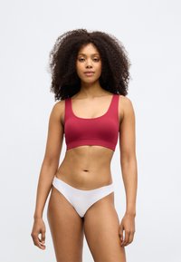 Červený rebrovaný crop top so širokými ramenami a bielym nízkym tangom. Hladká textura s priliehavým, športovým strihom a minimom švov.