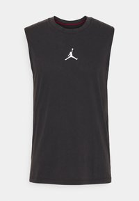 Maglietta nera senza maniche in cotone, con scollatura rotonda e un logo Jumpman bianco sul petto. Texture liscia.