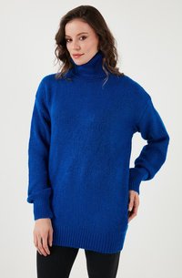 Blauwe coltrui gemaakt van een gestructureerd breimateriaal. Ribbelstructuur bij de boorden en de onderkant. Oversized, relaxte pasvorm met lange mouwen.