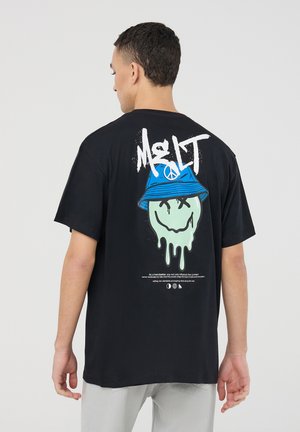 T-shirt in cotone nero con una grande grafica sul retro: un volto sorridente verde che cola, indossante un cappello a secchiello blu, con il testo "MELT" sopra.