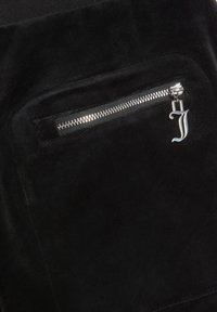 Zwarte suède stof met een zilveren ritszak, voorzien van een ritslip die de vorm heeft van de letter "J." Gladde textuur en eenvoudig ontwerp.